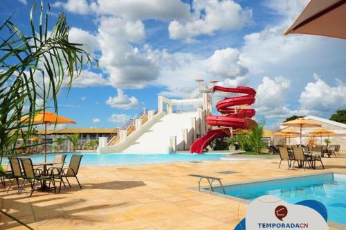 una piscina del complejo con un tobogán de agua rojo en L'acqua diRoma 12345 - Gualberto, en Caldas Novas