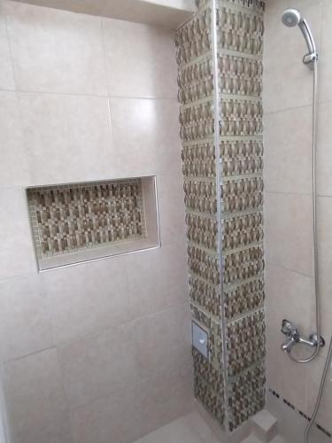 ein Bad mit einer Dusche und einer Steinmauer in der Unterkunft Jujuy Boutique in San Salvador de Jujuy