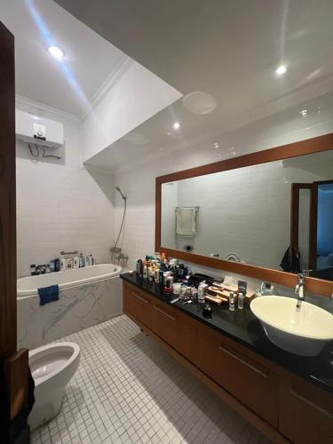a bathroom with a sink and a toilet and a mirror at Semesta Villa Jimbaran in Jimbaran