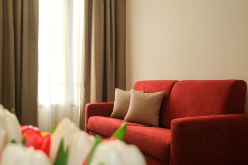 a red couch with two pillows in a living room at Emerald Green Residence in Caldiero