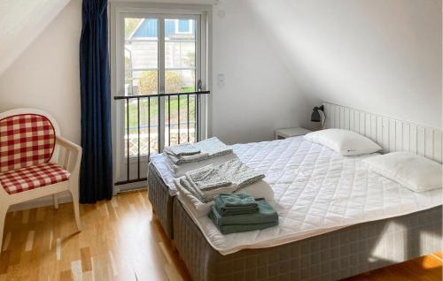 Lovely Home In Munka-ljungby With Wifi في Munka-Ljungby: غرفة نوم بسرير وكرسي ونافذة