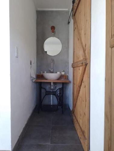 uma casa de banho com um lavatório e um espelho em CALIDO QUINCHO em Tandil