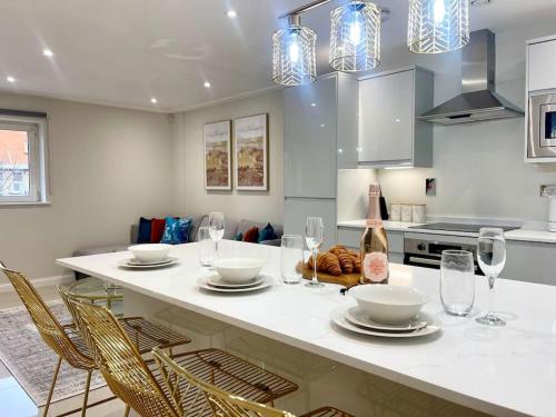 a kitchen with a table with chairs and wine glasses at Stylish Urban Escape Cardiff Bay Free Parking in Cardiff