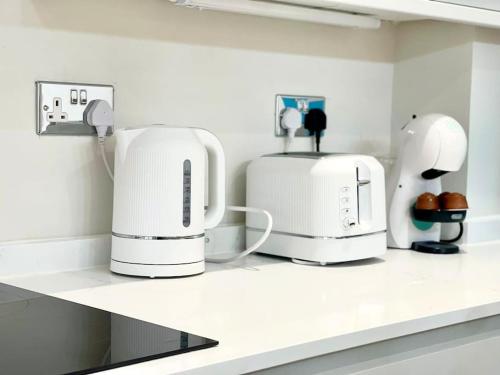 a kitchen with two white coffeemakers on a counter at Stylish Urban Escape Cardiff Bay Free Parking in Cardiff