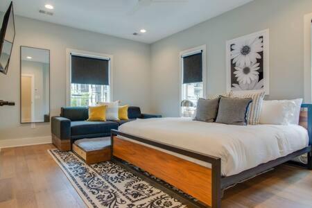 a bedroom with a large bed and a couch at Taylor Haus - Downtown Glam with Chic Rooftop in Nashville