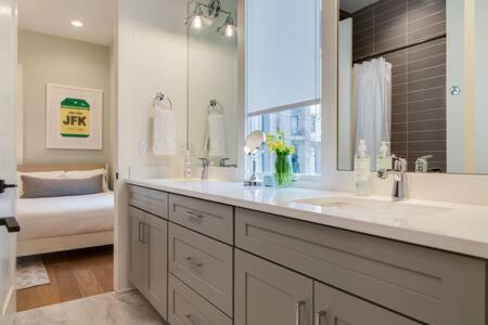 a bathroom with two sinks and a large mirror at Taylor Haus - Downtown Glam with Chic Rooftop in Nashville