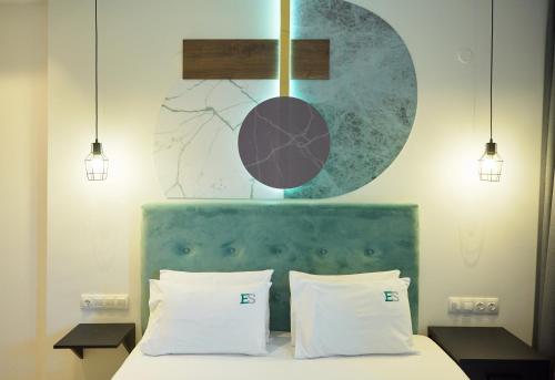 a bedroom with a bed with a blue headboard and two lights at Urban Elephant Suites in Thessaloniki