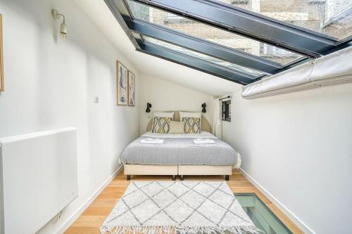 ein Schlafzimmer mit einem Bett und einem Dachfenster in der Unterkunft Loft proche Montparnasse in Paris