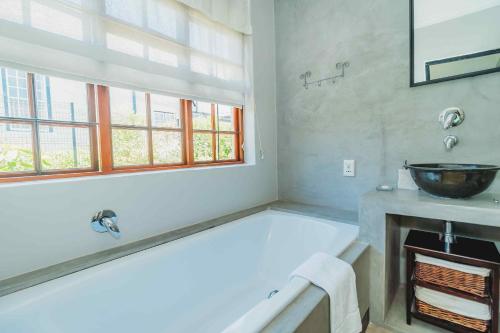 a bathroom with a large tub and a sink at Atello Guesthouse in George