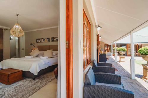 a bedroom with a bed and some blue chairs at Atello Guesthouse in George