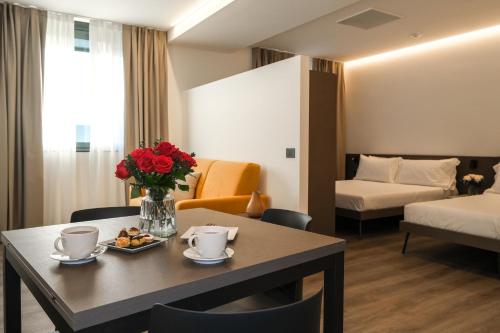 a hotel room with a table with flowers and a bed at Emerald Green Residence in Caldiero