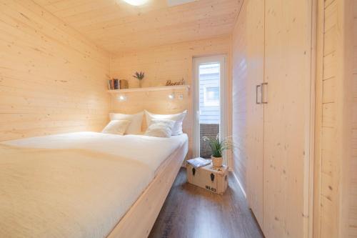 a bedroom with a bed in a wooden room at Hausboot The Goose in Burgstaaken