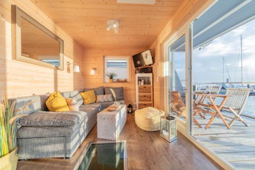 a living room with a couch and a table at Hausboot The Goose in Burgstaaken