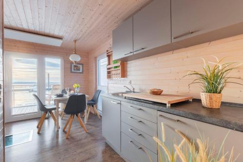 a kitchen and dining room with a table and chairs at Hausboot The Goose in Burgstaaken