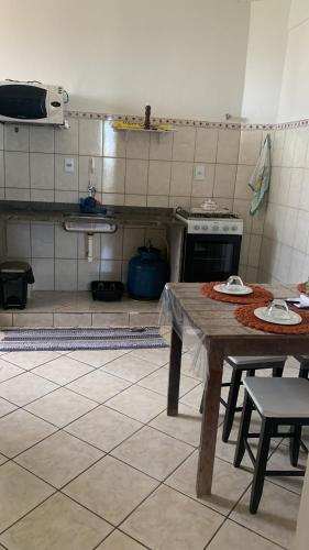 eine Küche mit einem Holztisch und einem Herd in der Unterkunft Bela vista a beira mar in Marataizes