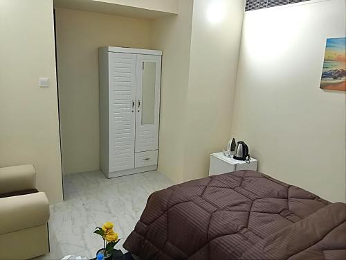 MBZ - Pleasant Stay في أبوظبي: غرفة نوم مع سرير وخزانة بيضاء
