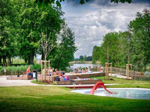 a group of people sitting in a park with a playground at traumhafte Business & Relax Wohnung direkt im Stadtkern Oettingens by Elation Homes in Oettingen in Bayern