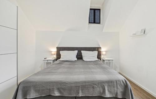 a bed in a white room with two tables at Ferienwohnung Maja in Loxstedt