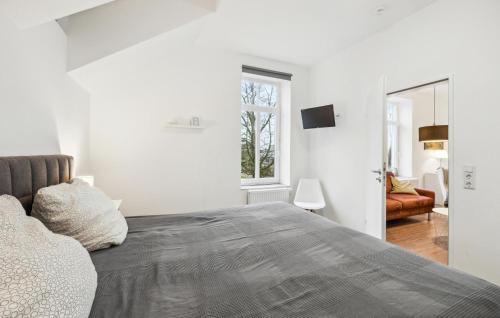 a white bedroom with a bed and a mirror at Ferienwohnung Maja in Loxstedt