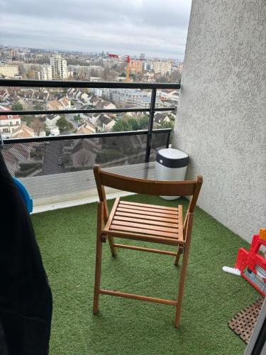 d'une table et d'une chaise sur un balcon avec vue. dans l'établissement Appartement à 5km du stade de France, à Villeneuve-la-Garenne