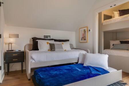 a bedroom with two beds and a blue blanket at Taylor Haus II - Stylish Stay with Rooftop, Close to Fun in Nashville