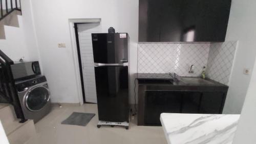 uma cozinha com um frigorífico e uma máquina de lavar roupa em Chandra's House em Denpasar