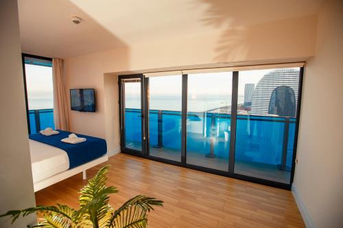a room with a bed and a balcony with a view at Panorama Sea View Orbi City Aparthotel Batumi Beach in Batumi