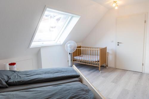 a bedroom with a bed and a window and a crib at Wohnung am Bodensee in Moos