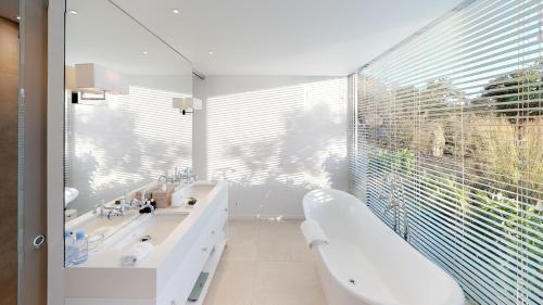 baño con 2 lavabos y ventana grande en Hotel Le Toiny, en Gustavia