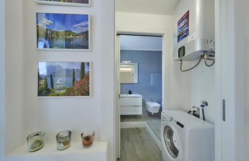 a white bathroom with a washer and dryer in it at Majestic Sunrise Bellagio in Bellagio
