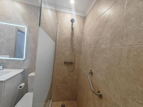 uma casa de banho com um chuveiro, um WC e um lavatório. em Brisa Atlântica em Portimão