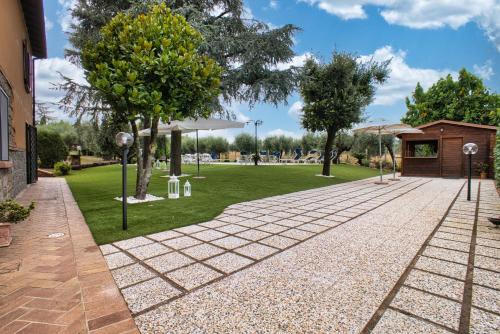 a brick walkway with trees in a park at B&B Casale Ansamagi Relax & Pool in Genzano di Roma