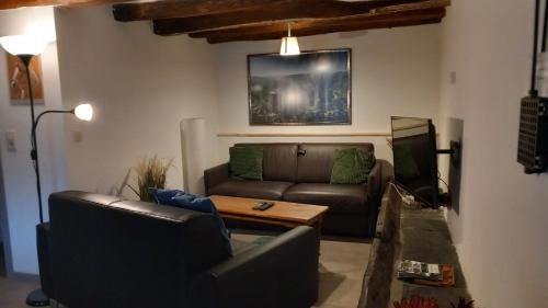 a living room with a couch and a table at Gîte Le Courtil in Bouillon