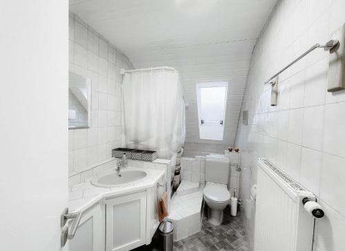 a white bathroom with a sink and a toilet at Wohnung am Bodensee in Moos