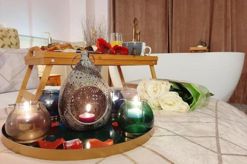 une table avec des bougies et un plateau avec une table avec des roses dans l'établissement Luxury Suite Paris Republique, à Paris