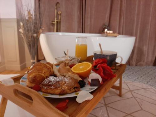 - un plateau de petit-déjeuner sur une table avec une baignoire dans l'établissement Luxury Suite Paris Republique, à Paris