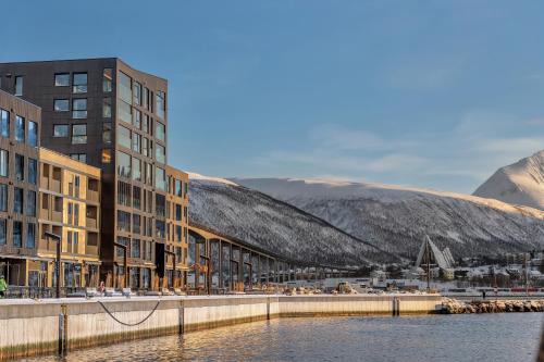 una ciudad con edificios y un río y montañas en Vervet - Seaview Apartment, en Tromsø