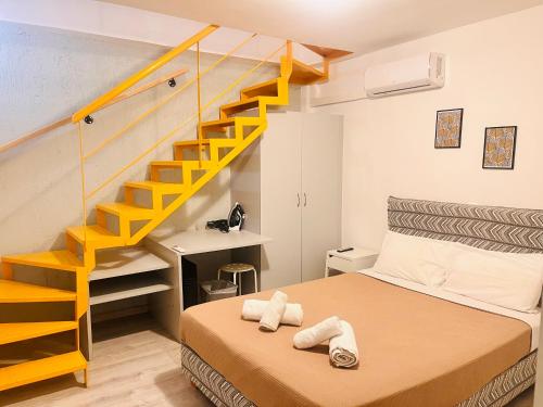 Elvita Apartments في أثينا: غرفة نوم بسرير ودرج اصفر