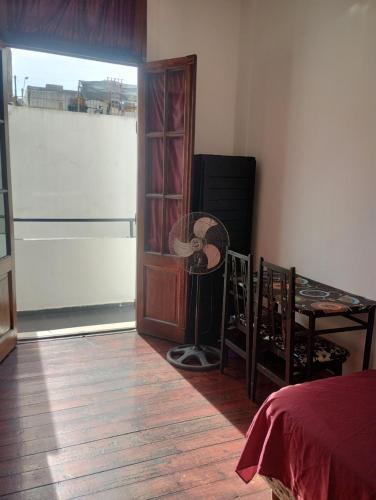 a room with a bedroom with a fan and a window at Hotel Minerva in Buenos Aires