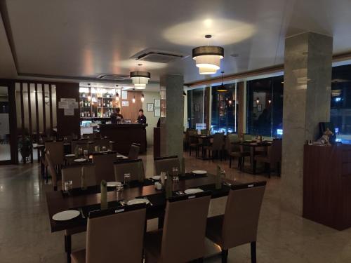 迪布鲁加尔Hotel Tree Fern的餐厅里有桌椅的餐厅
