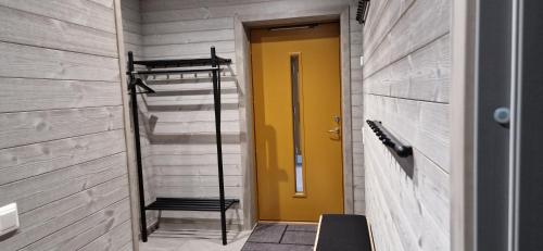 a yellow door in a hallway with a staircase at Funäsdalshöjden Funäsdalen in Funäsdalen