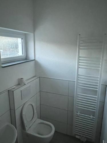 La salle de bains est pourvue de toilettes et d'une fenêtre. dans l'établissement Ferienwohnung-Monteurwohnung, à Hombourg