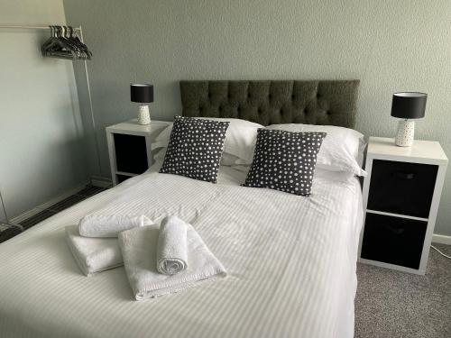 a white bed with pillows and towels on it at Quiet Ground Floor apartment with parking in Morecambe
