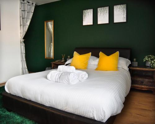a bedroom with a large bed with yellow pillows at Hermitage, 3 Bed entire House in Loughborough in Loughborough