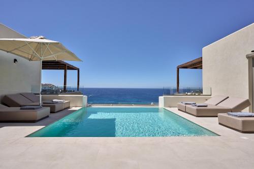a swimming pool with a view of the ocean at Ios Grand Pool Suites in Mylopotas