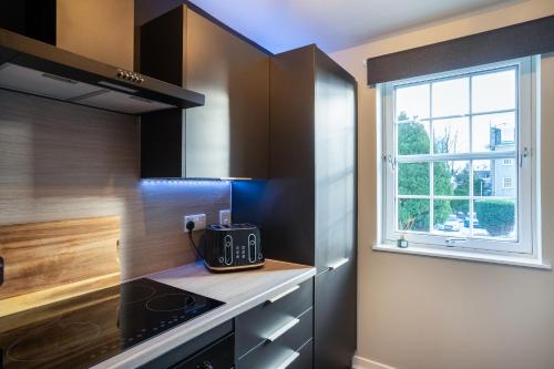 una cucina con piano cottura forno superiore accanto a una finestra di Central-1Bed Flat-Free Parking ad Aberdeen