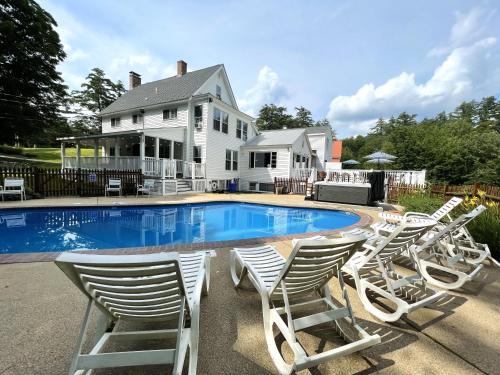 um grupo de cadeiras sentadas em torno de uma piscina em Cranmore Mountain Lodge Bed & Breakfast em North Conway