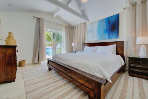 a bedroom with a large bed and a large window at Incredible Beach Front Villa! in George Town