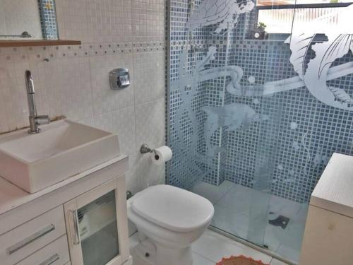 a bathroom with a toilet and a sink and a shower at Apartamento na aviação in Praia Grande