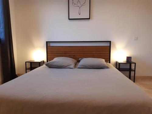 um quarto com uma cama grande e 2 almofadas em Gîte du Colombier em Crestet